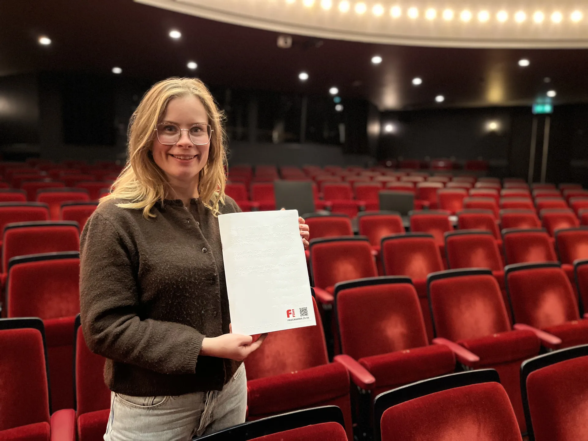 Marianne met de braillefolder in haar hand