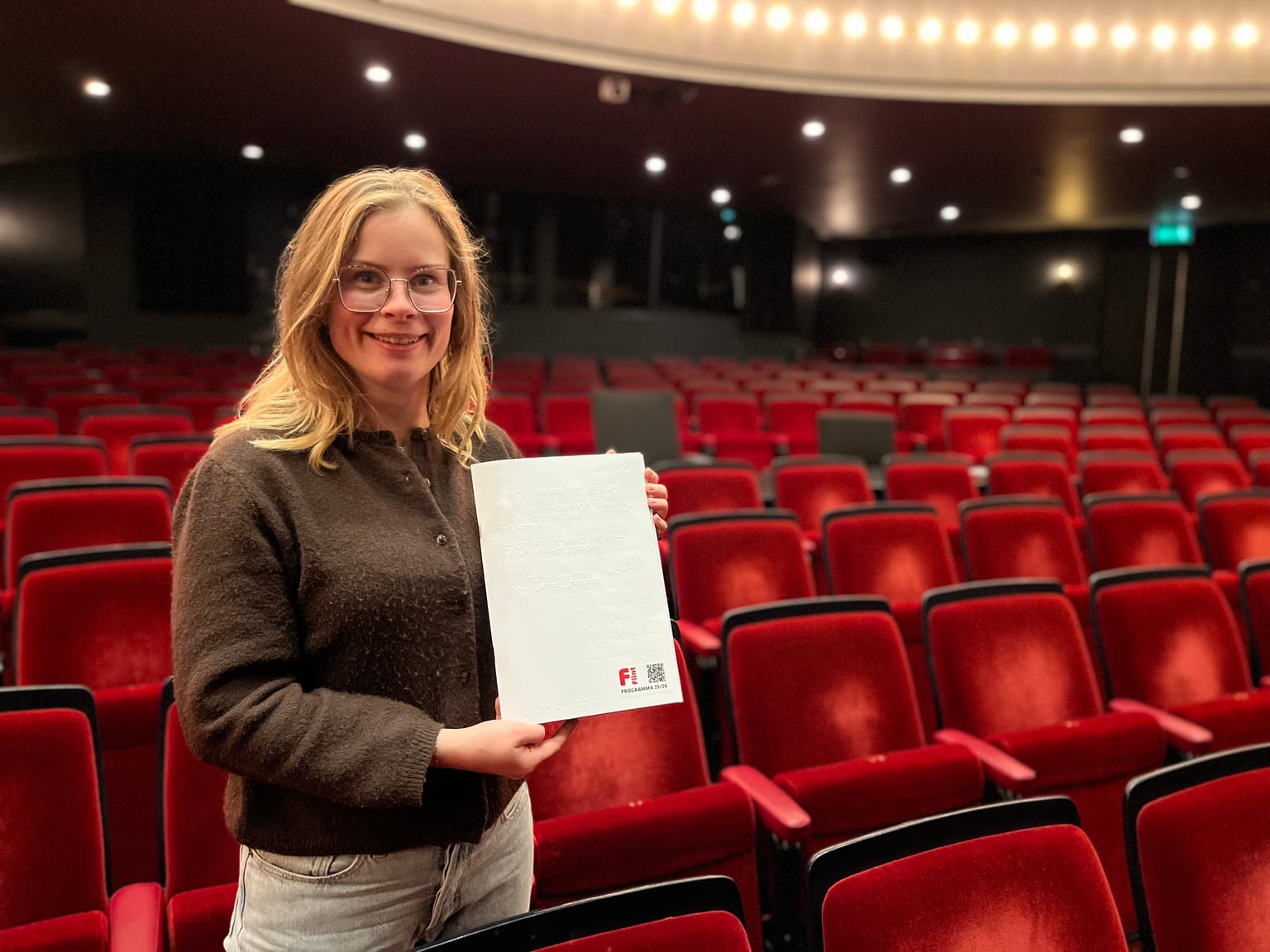 Marianne met de braillefolder in haar hand